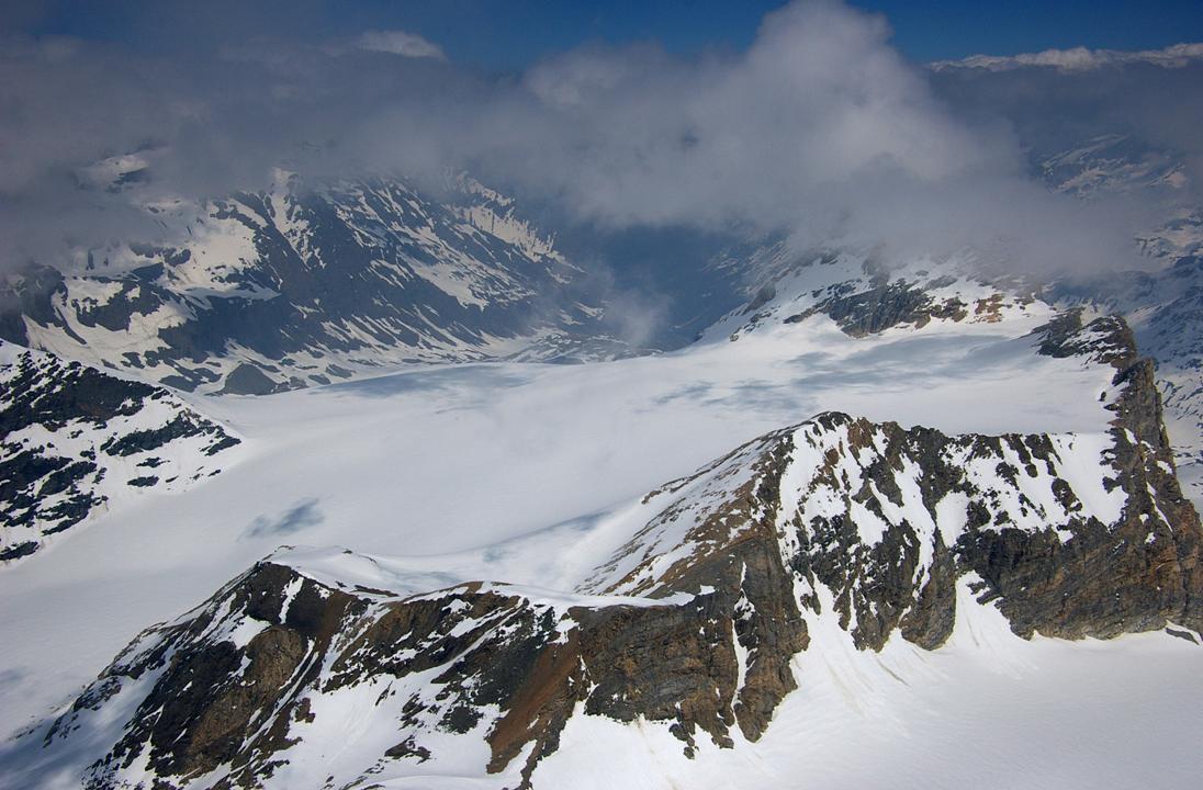 Glacier de Rhèmes Golette : Avec à sa droite, en contrebas de la muraille rocheuse, le glacier de Sauches, pris comme itinéraire de descente sur le Refuge Benevolo. Dans le nuage à droite, les Granta Parei, sommet référent du val di Rhêmes.