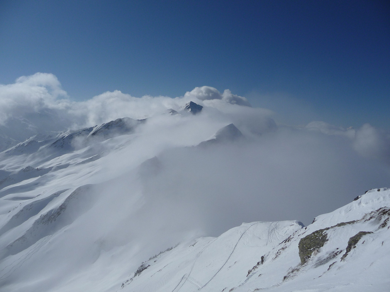 Vue du sommet : Le grand Arc émerge des nuages