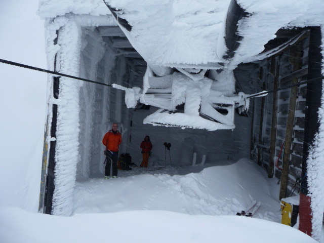 #7 Pause déjeuner : Anne et Didier à l Pause déjeuner : Anne et Didier à l'abri du vent et de la neige au niveau de la gare d'arrivée d'un télésiège fermé depuis longtemps.