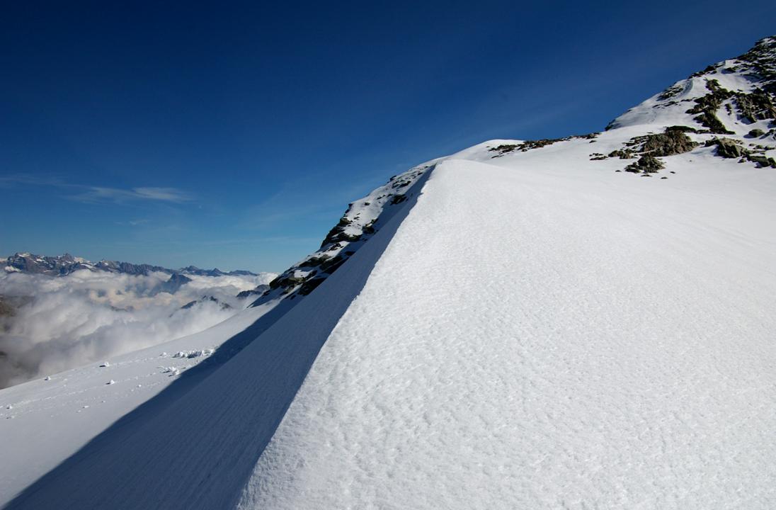Sur une dune de neige : Relief glaciaire sculpté pour accéder à la face, les versants italiens se découvrent.
