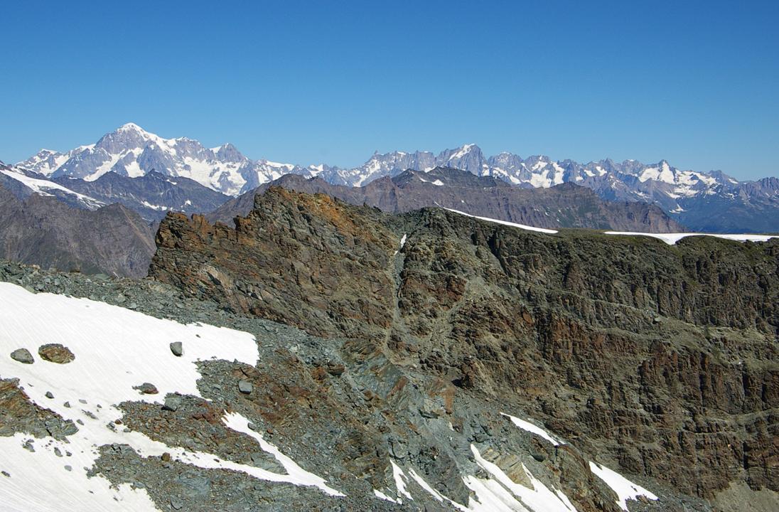 La chaîne du Mont-B valdotaine : Emergeant au dessus de la Cima Percia (3212), et la Costa la Manteau... la chaine du Mont-Blanc devient tout en longueur. Paradoxe visuel... elle est longiligne, et gomme ses "aspérités"