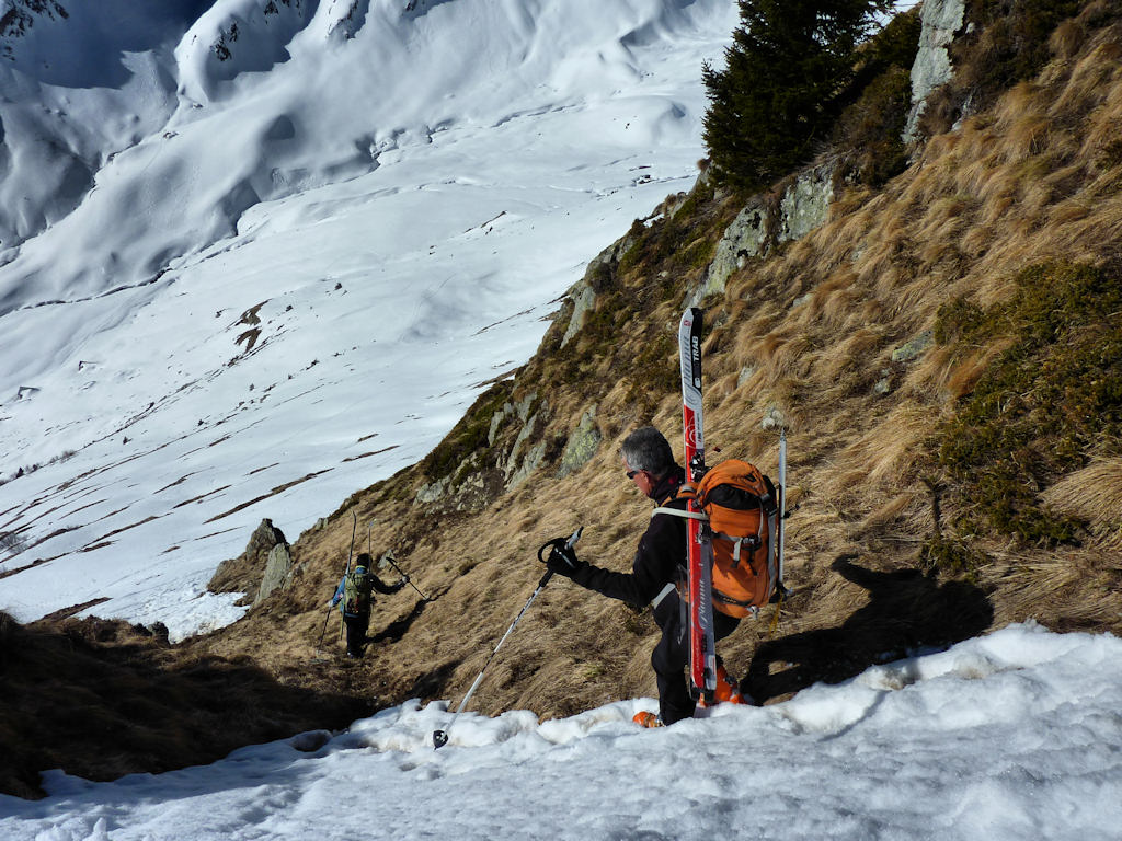 Descente versant Sud : Skis sur le sac.