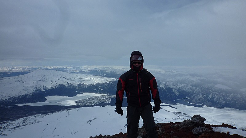 Sommet : Didier au sommet avec la Laguna Conguillo en arrière plan en bravant le vent violent