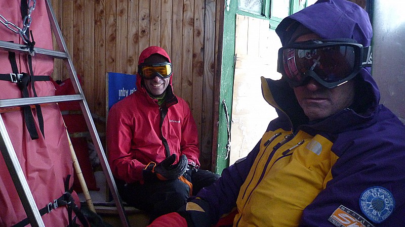 A l'abri : Eric et Yves à l'abri pour manger dans la cabane du télésiège fermé car trop de vent